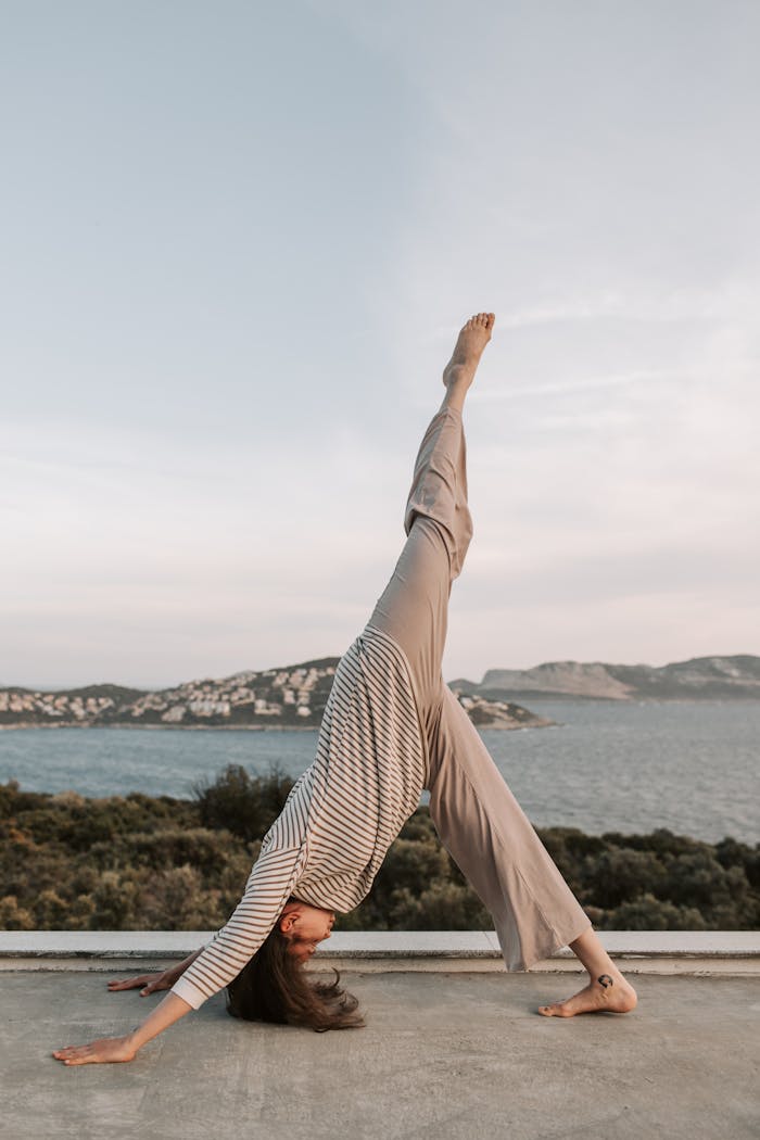 Services A woman practicing yoga on a terrace with a stunning sea view in Antalya, Turkey at sunset.